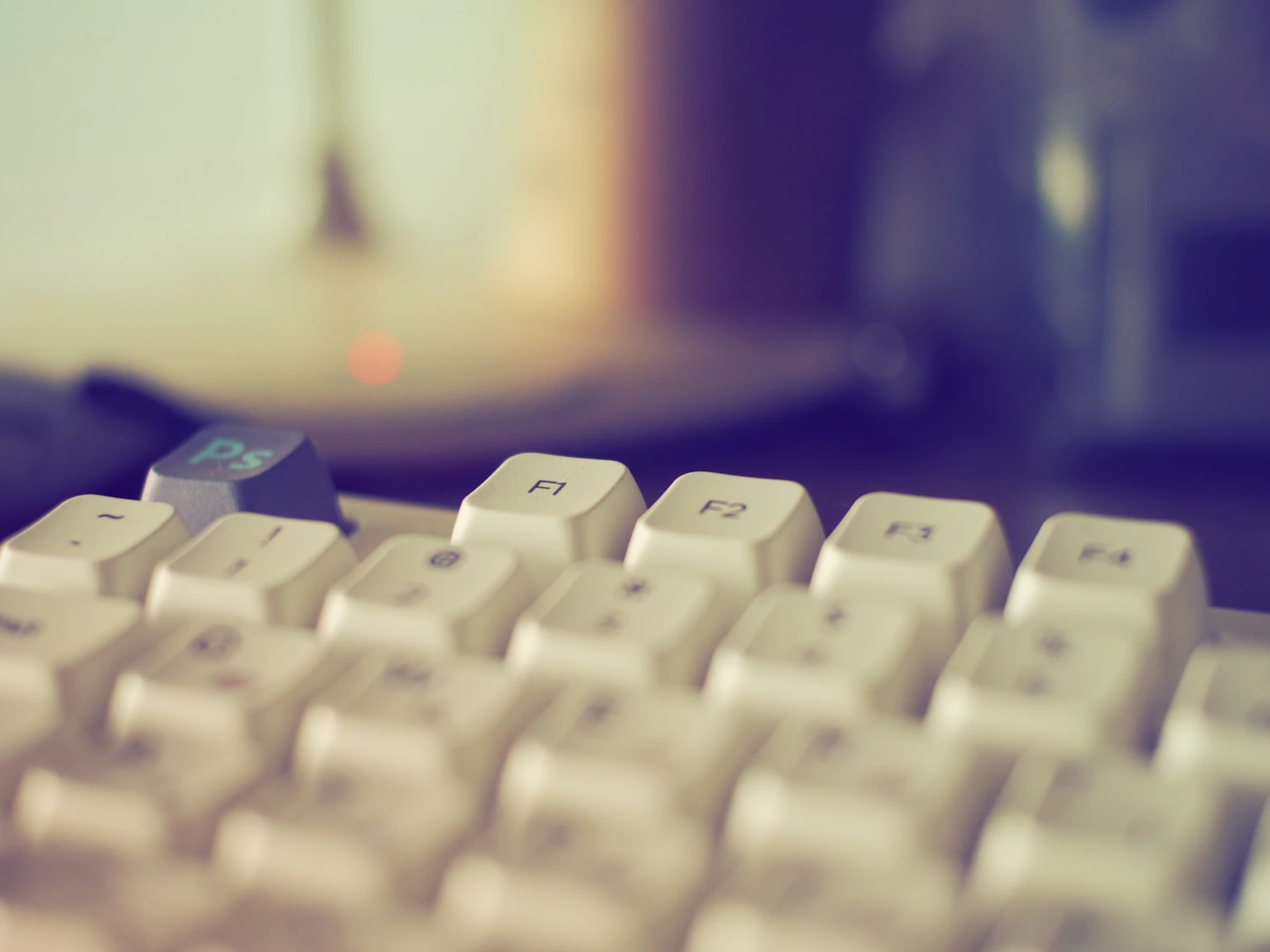 Close-up of a white computer keyboard with a blue key