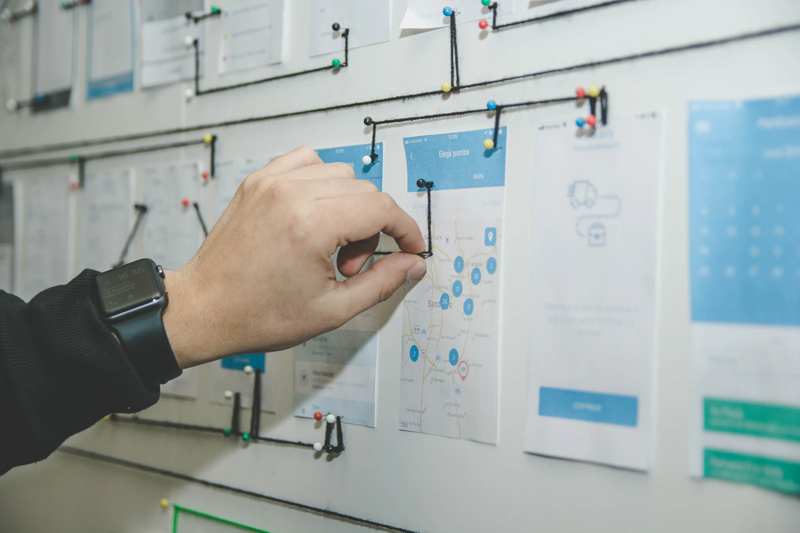 Person mapping a software workflow on a blue and white planning board